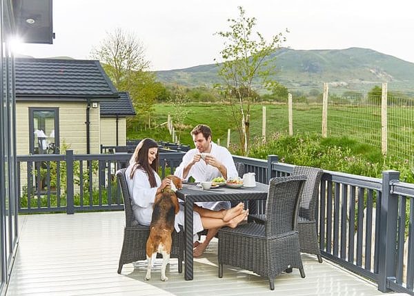 Couple having breakfast at the veranda with their dog